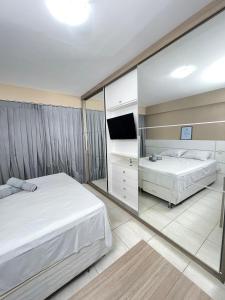 a bedroom with two beds and a large mirror at Suíte premium de alto padrão II - Climatizado in Feira de Santana