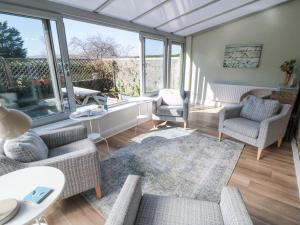 a living room with couches and chairs and windows at Barn Cottage in Saltburn-by-the-Sea
