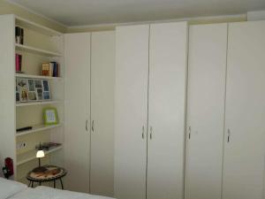 1 dormitorio con armarios blancos, 1 cama y 1 mesa en my, your, our holiday apartment, en Cuxhaven