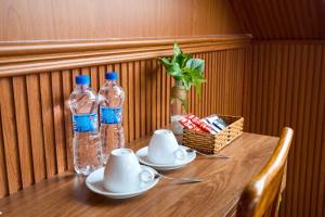 un tavolo in legno con due bottiglie d'acqua di Lotus Hotel Đà Lạt a Khu Chi Lăng