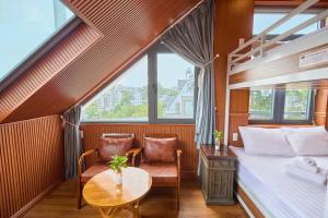 una camera da letto con un letto, un tavolo e delle sedie di Lotus Hotel Đà Lạt a Khu Chi Lăng