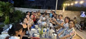 a group of people sitting at a long table at Vườn Dừa Cam Bình 1 in La Gi