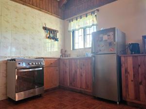 a kitchen with a stove and a refrigerator at Te Ra'a Travel - Cabaña equipada in Hanga Roa