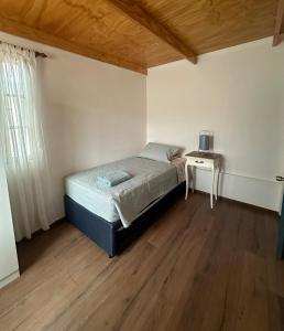 een kleine slaapkamer met een bed en een tafel bij Casa cómoda y acogedora en San Pedro de Atacama in San Pedro de Atacama