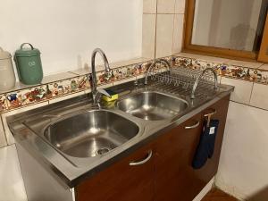 een roestvrijstalen wastafel in een kleine keuken bij Casa cómoda y acogedora en San Pedro de Atacama in San Pedro de Atacama +26 foto's