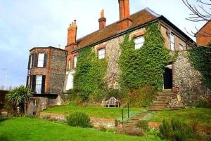an old brick house with ivy growing on it at Castle House Hotel in Canterbury