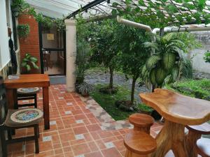 a patio with a table and chairs and plants at Home Capybara Stay in Mindo