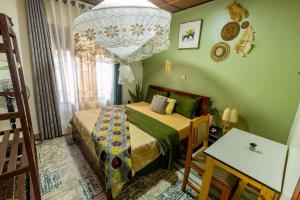 a bedroom with a bed and a chandelier at AlyChe Home in Kigali