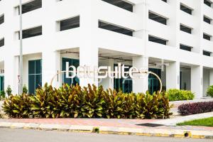 a white building with a sign in front of some plants at Liwan, Baysuite by Ayuhouz in Kota Kinabalu