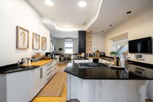 a large kitchen with white cabinets and black counter tops at No. 5 East in Winnipeg