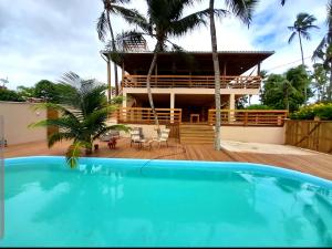 a house with a swimming pool in front of a house at Sol do Gostoso Bangalô in São Miguel do Gostoso