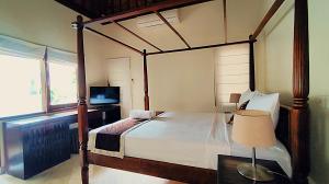 a bedroom with a canopy bed and a table with a lamp at Villa Diana Bali in Legian +40 photos