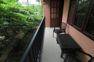 a balcony with two chairs and a table at Wayanad One in Wayanad +43 photos