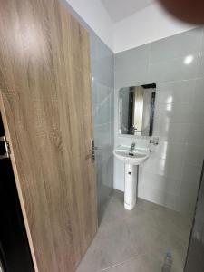 a bathroom with a sink and a wooden door at Ali Vista Vactions in Daidatz