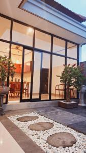 a house with a patio with rocks and windows at Aksamala Villa Echobeach Canggu in Canggu +8 photos