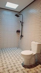 a bathroom with a white toilet in a room at Aksamala Villa Echobeach Canggu in Canggu