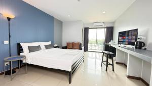 a bedroom with a bed and a desk in it at Baan Paknam Budget Hotel in Samut Prakan