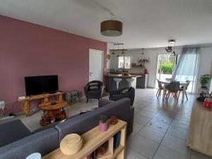 a living room with a blue couch and a table at Maison à Escource avec Jardin et Accès Forêt - FR-1-50-166 in Escource
