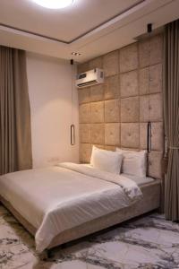 a bedroom with a large white bed in a room at Yokolo Luxury Apartments, Katampe in Jiru
