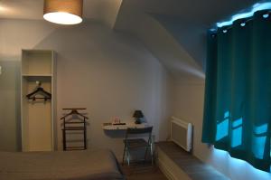 a bedroom with a bed and a desk and a table at L'annexe in Le M&ecirc;le-sur-Sarthe