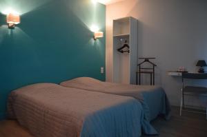 a bedroom with two beds and a green wall at L'annexe in Le M&ecirc;le-sur-Sarthe