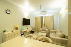 グルガオンにあるPosh 1BR Apartment In Gurugram With Club Facilitiesのソファとテレビのあるリビングルーム