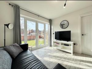 a living room with a couch and a tv at Doncaster 2-Beds Sleeps 4 with Parking in Doncaster