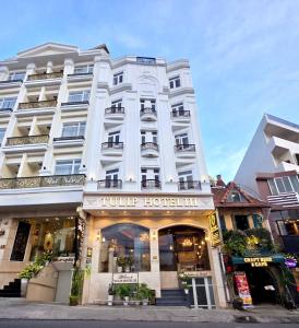 a large white building with a hotel at Tulip Hotel 3 in Da Lat