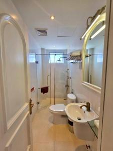 a bathroom with a toilet and a sink and a shower at Tulip Hotel 3 in Da Lat