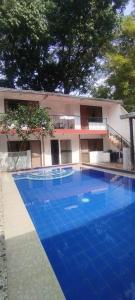 a large blue swimming pool in front of a building at Hotel la Isabella SM in Villeta