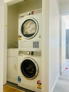 a washing machine and a washer and dryer in a room at Alpine Rest! Brand new! Cozy&Convenient! in Queenstown +1 photo