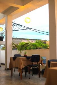 a dining room with a table and chairs and a window at Beach Royal Hub Hotel & Restaurant in Negombo