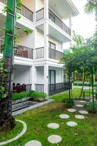 a large white building with a garden in front of it at Pich Kunthea Angkor Resort in Phumĭ Kruŏs