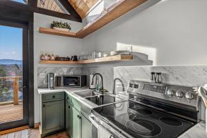 une cuisine avec un évier et une cuisinière dans l'établissement The Flame Azalea - Luxury Treehouse - Hot Tub, Wi-Fi, Soaring Views, 10 Min to PF - Perfect for Couples!, à Sevierville