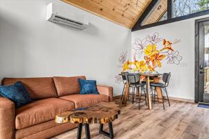 un salon avec un canapé et une table dans l'établissement The Flame Azalea - Luxury Treehouse - Hot Tub, Wi-Fi, Soaring Views, 10 Min to PF - Perfect for Couples!, à Sevierville