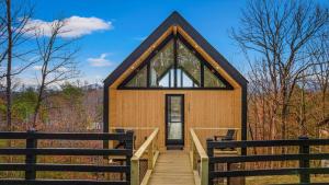 une petite maison sur une rampe en bois avec une fenêtre dans l'établissement The Flame Azalea - Luxury Treehouse - Hot Tub, Wi-Fi, Soaring Views, 10 Min to PF - Perfect for Couples!, à Sevierville 45 autres photos
