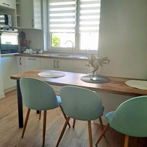a kitchen with a wooden table and four chairs at Zlata Imperium Residence 12profi in Suceava
