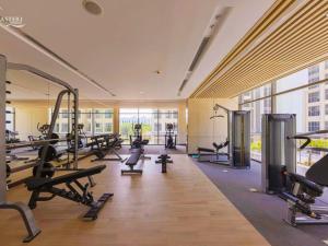 une salle de sport avec de nombreux tapis roulants et machines dans l'établissement Sunny Deluxe Apartment 1-bedroom And 1-living Room, à Gia Lâm Pho