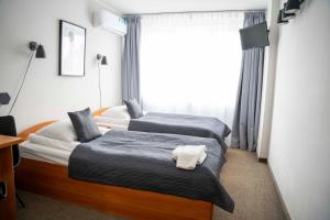 dwa łóżka w pokoju hotelowym z oknem w obiekcie Lofft Hotel w mieście Ciechanów