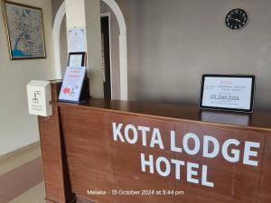 a hotel reception desk with a sign that reads kota lodge hotel at Kota Lodge Guest House in Malacca