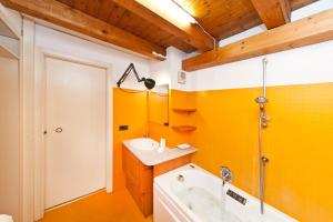 baño con paredes amarillas, lavabo y bañera en Venice Samoro Jacuzzi, en Venecia