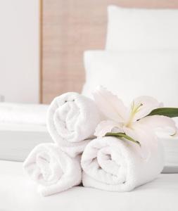 a pile of towels on a table with a flower at Meson Cavour in Avigliano +14 photos