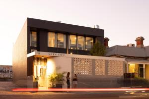 two people are standing outside of a building at Spin Off Hostel in Perth