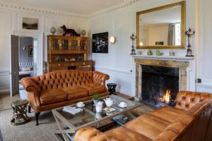 a living room filled with furniture and a fire place at The Slaughters Manor House in Lower Slaughter