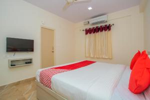 a bedroom with a bed and a flat screen tv at The Pride Hill-tone in Bangalore