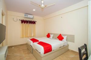 a bedroom with a bed with red pillows at The Pride Hill-tone in Bangalore