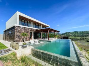 a house with a swimming pool in front of it at Villa Pseudechis - SeaView - Construction Nearby in Selong Belanak +23 photos