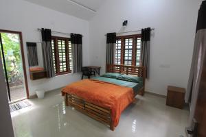 a bedroom with a bed in a room with windows at Wayanad One in Wayanad
