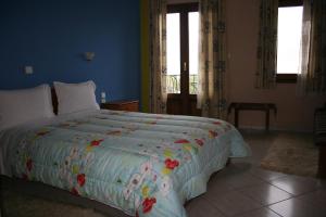 a bedroom with a large bed with a colorful comforter at Guesthouse Mitsiopoulou in Neochori