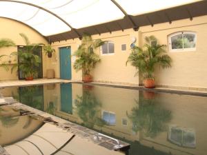 ein Swimmingpool mit Palmen in einem Gebäude in der Unterkunft The Village Apartments in Kapstadt + 7 Fotos